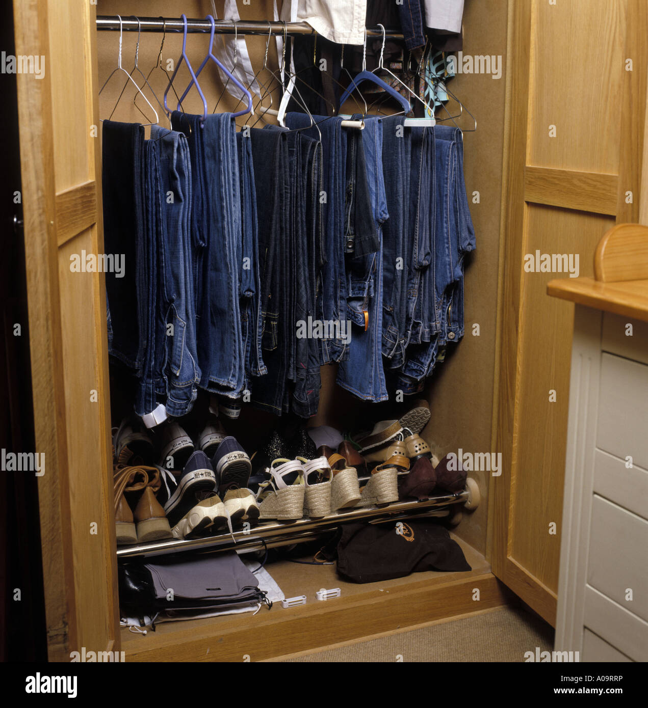 Una selección de los pantalones vaqueros y los zapatos en un armario  Fotografía de stock - Alamy