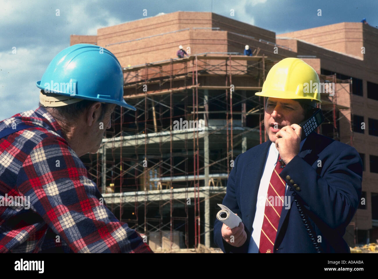 Supervisor de Obras utiliza teléfonos celulares de sitio en construcción Foto de stock