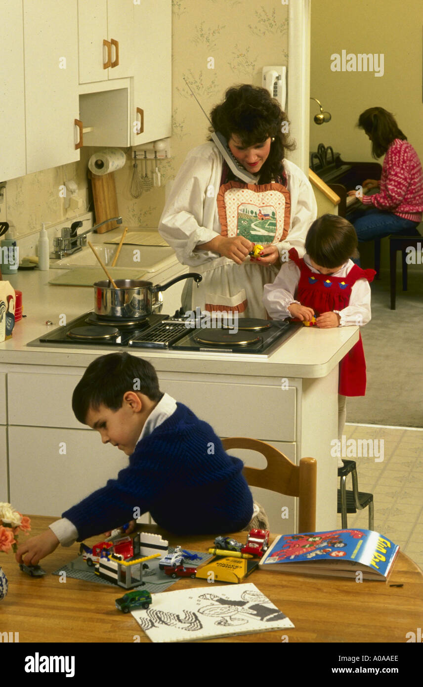 Mamá en la cocina cocinando con sus hijos modelo liberado Foto de stock