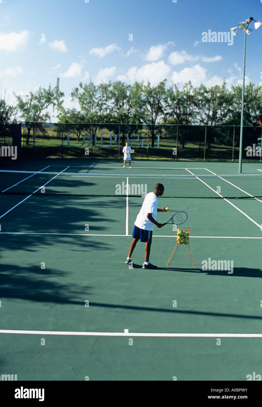 Jugar al tenis en el sol Foto de stock