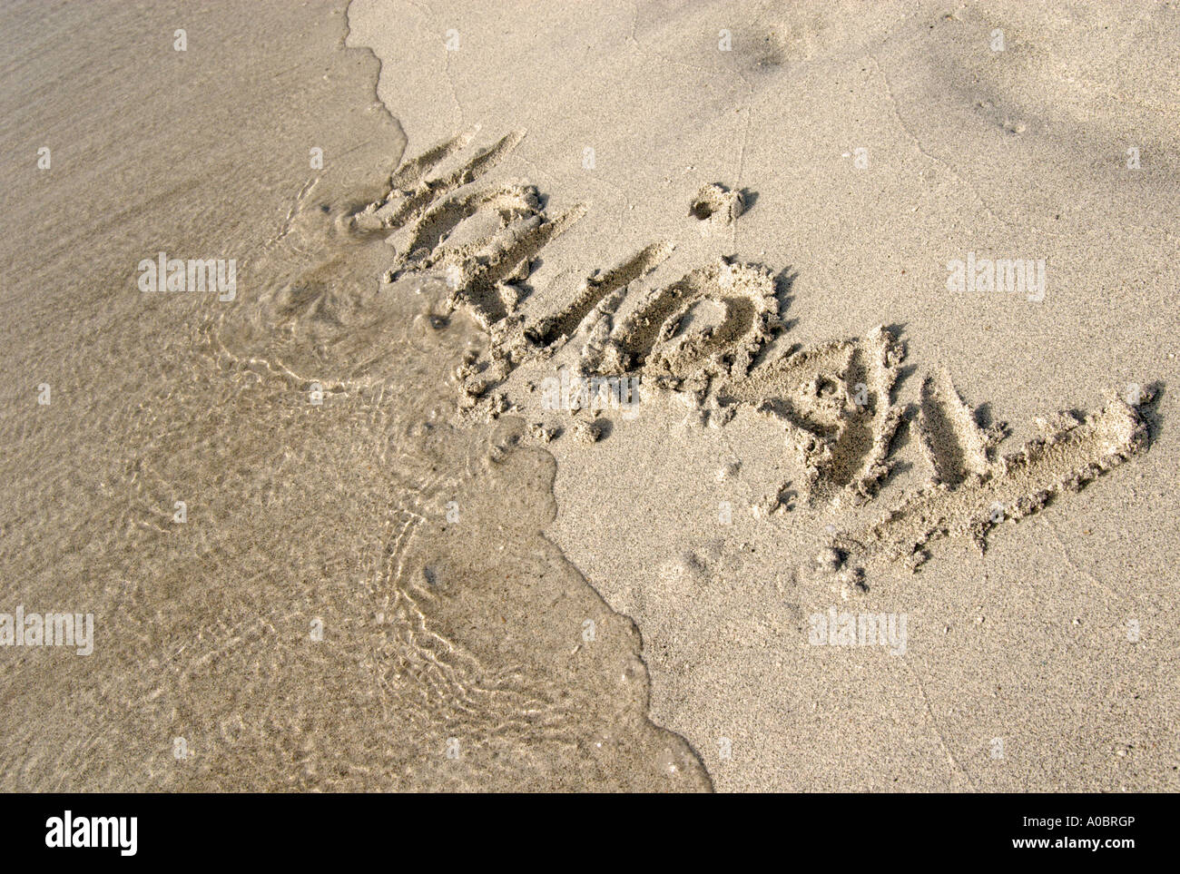 La palabra vacaciones escrito en la arena como un concepto de las vacaciones y vacaciones sensación cuando viaje lejos de todo en ho Foto de stock
