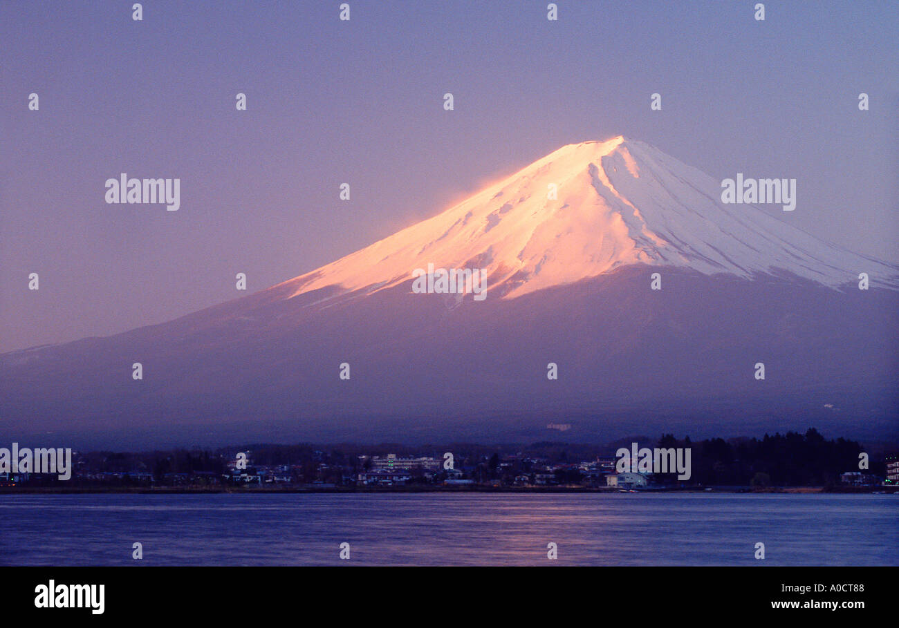 El monte Fuji al amanecer visto atravesando el Lago Kawaguchi con el complejo de Kawaguchi en la orilla Japón Foto de stock