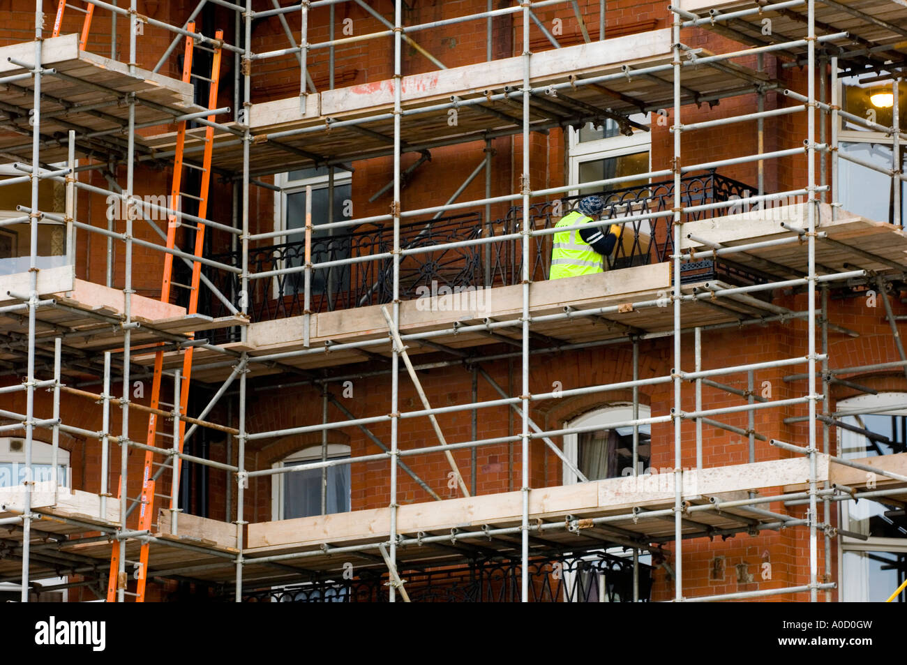 Trabajador de la construcción en un edificio scaffolded Blackpool UK Foto de stock