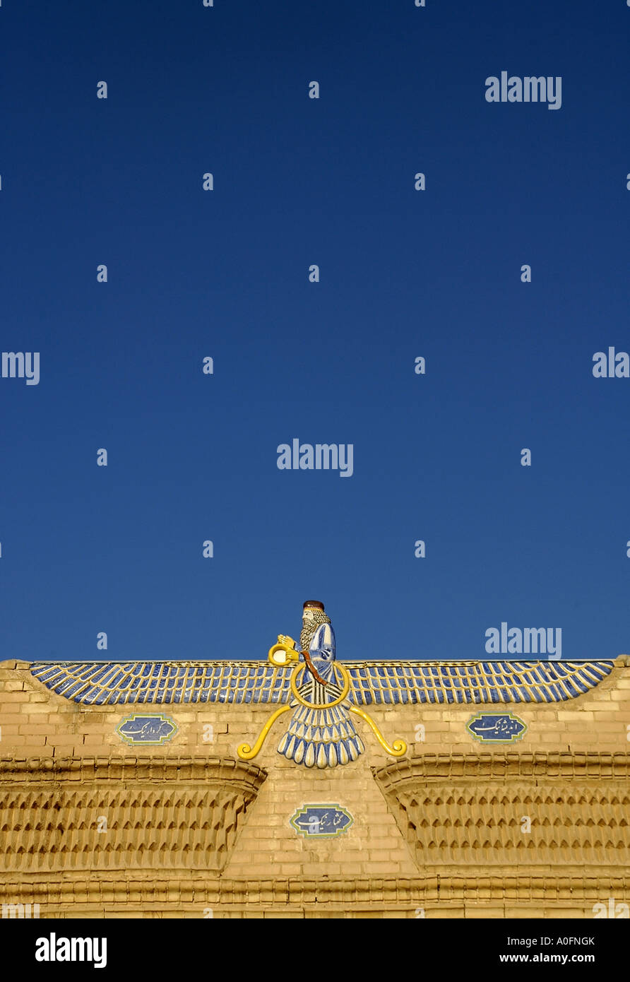 Una foto vertical del símbolo alado de la religion Zoroastriana, encima de la entrada del templo de fuego de Yazd, Irán. Foto de stock