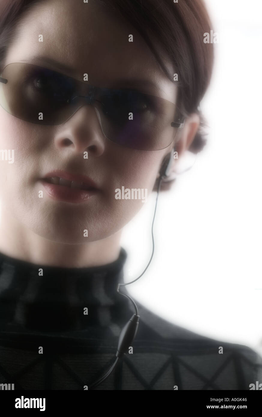 Mujer con gafas oscuras y auricular de teléfono Foto de stock