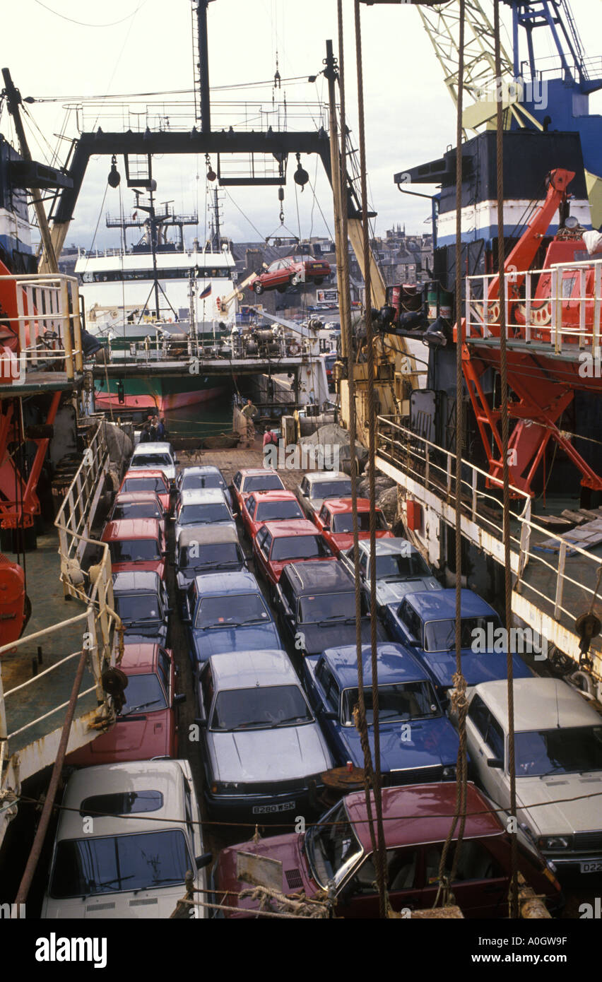 Aberdeen coches de segunda mano se cargan en los barcos de pesca rusos Para la exportación de vuelta a la Unión Soviética para la reventa y el repuesto Partes 1986 1980 Reino Unido HOMER SYKES Foto de stock