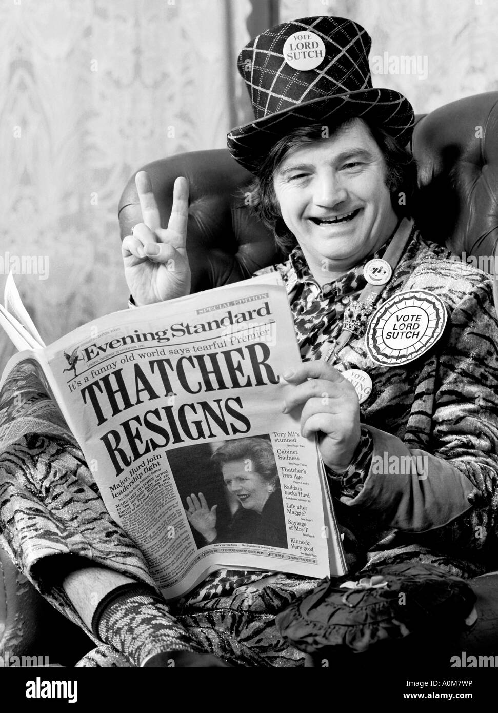 Screaming Lord Sutch en su casa leyendo las noticias de la Sra. Thatchers renuncia. Foto de stock