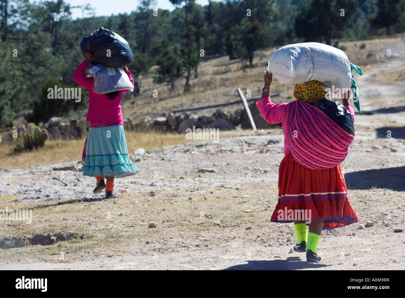 Las mujeres tarahumaras que transportaban mercancías entregado a la Misión de San Luis Majimachi en la Sierra Tarahumara cerca de la Barranca del Cobre Foto de stock
