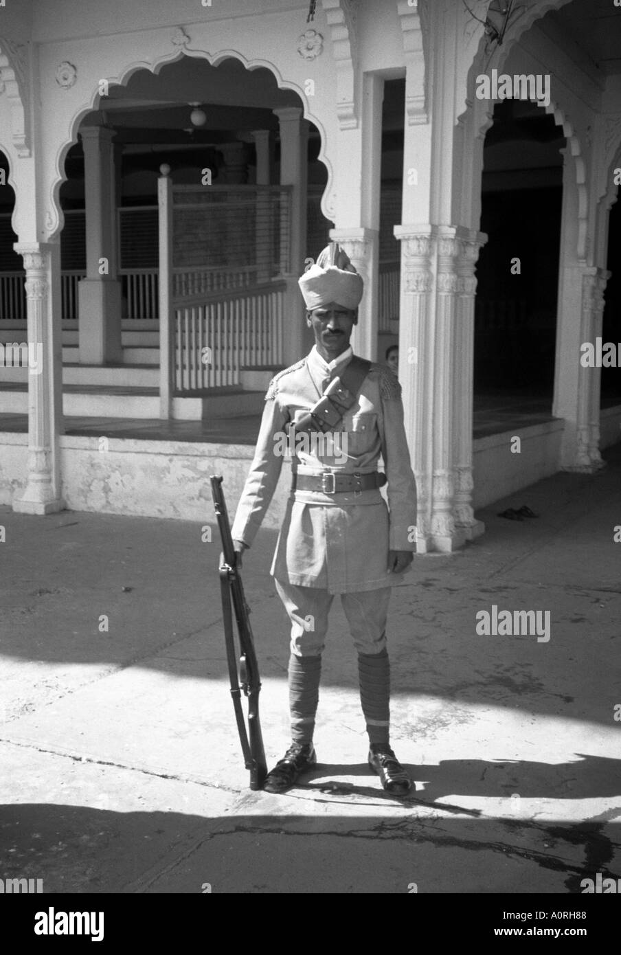 Hombre de pie vertical exterior plantean la tradición colonial de la calle de la guardia imperial rifle turbante hat Mysore Karnataka, India del sur de Asia Foto de stock