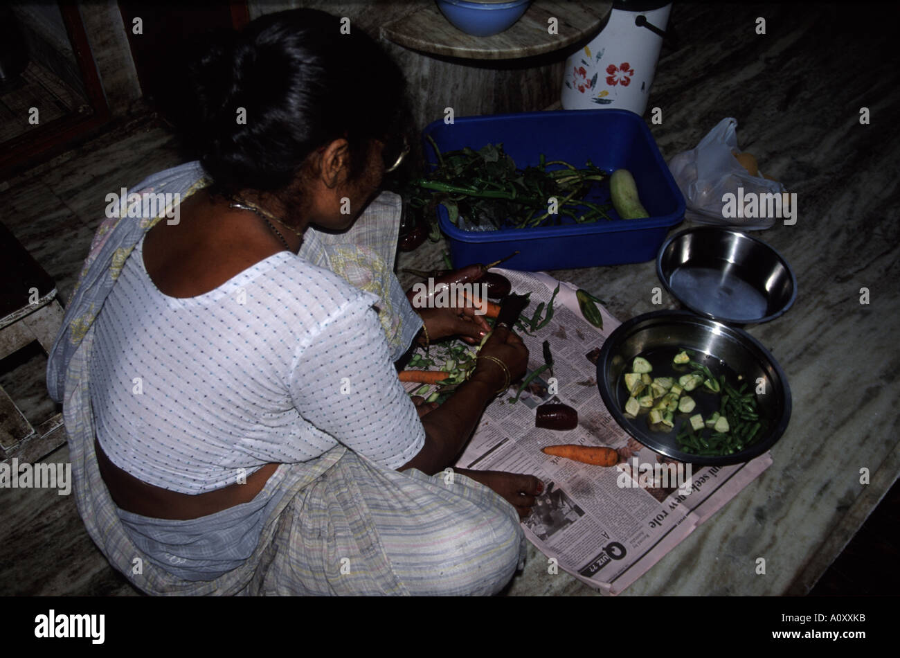 Preparación de verduras en el piso de una cocina en Kolkata (antes Calcuta, India Foto de stock