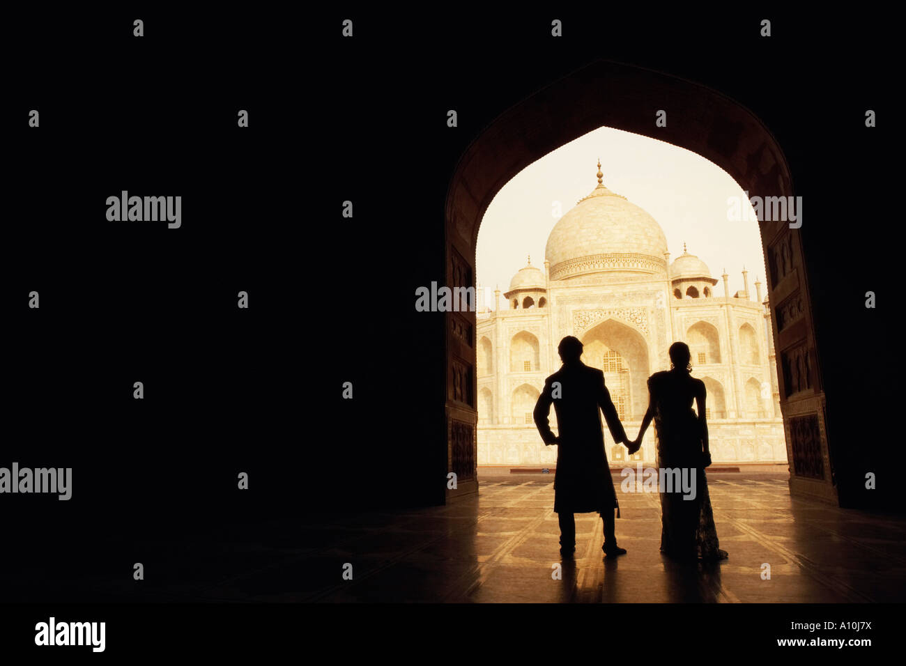 Silueta de una pareja de pie en frente de un mausoleo, Taj Mahal, Agra, Uttar Pradesh, India Foto de stock