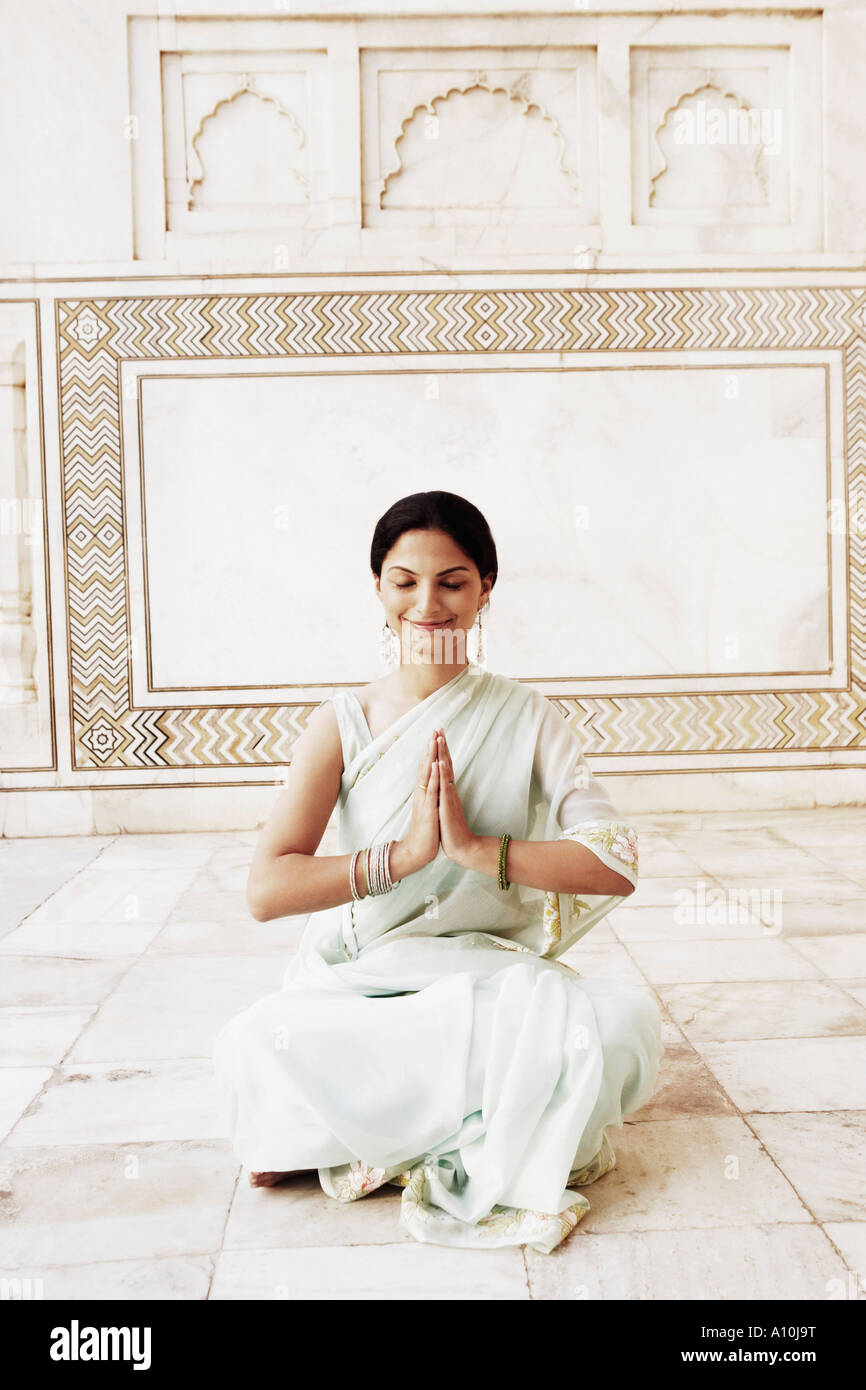 Mujer joven sentado en una posición de oración en un mausoleo, Taj Mahal, Agra, Uttar Pradesh, India Foto de stock