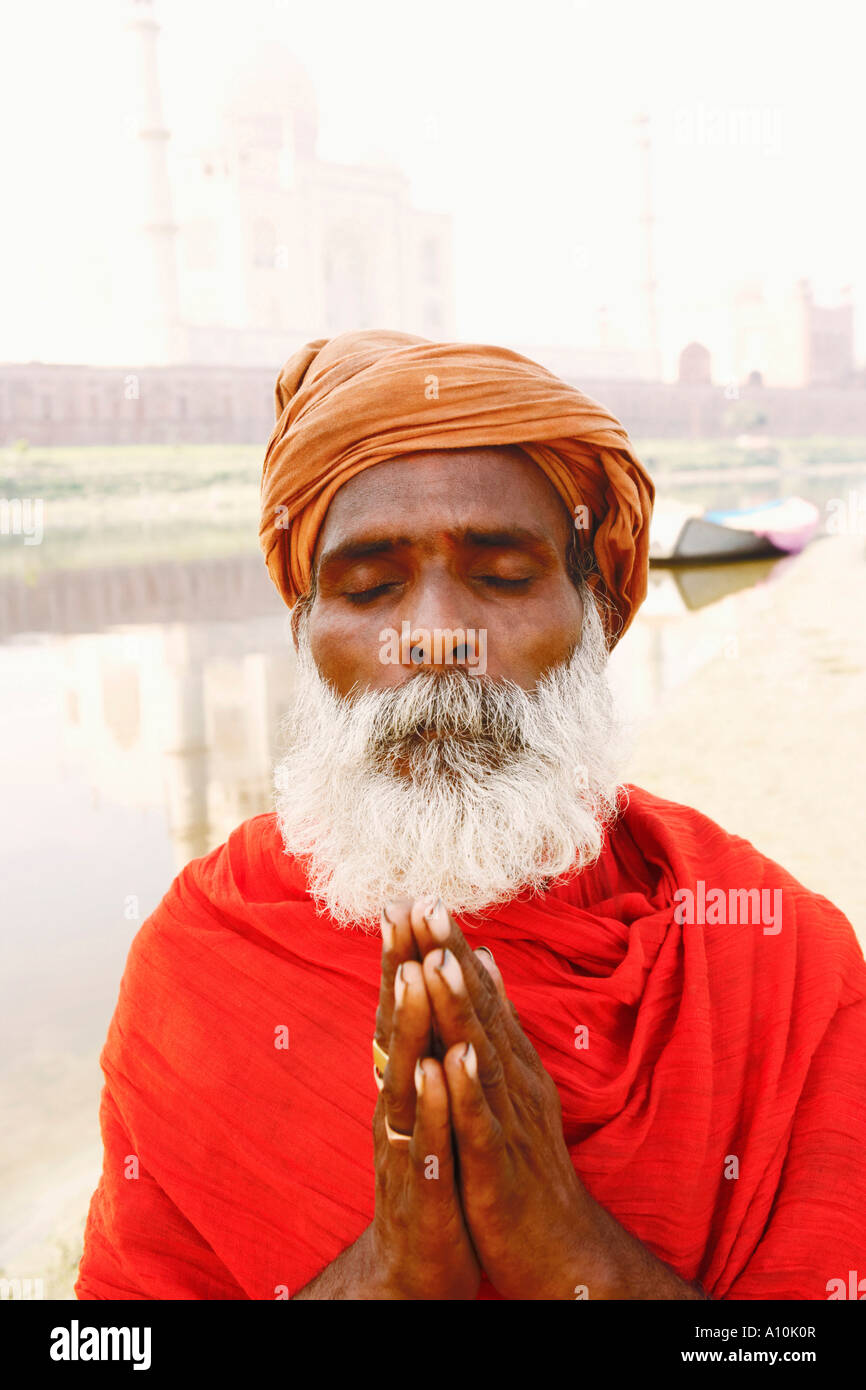 Close-up de un sacerdote de pie en una posición de oración en la orilla del río, el Taj Mahal, Agra, Uttar Pradesh, India Foto de stock