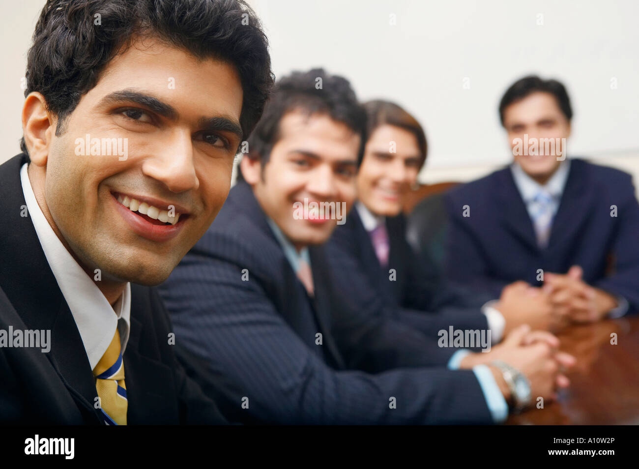 Retrato de cuatro empresarios sentado en una sala de conferencias Foto de stock