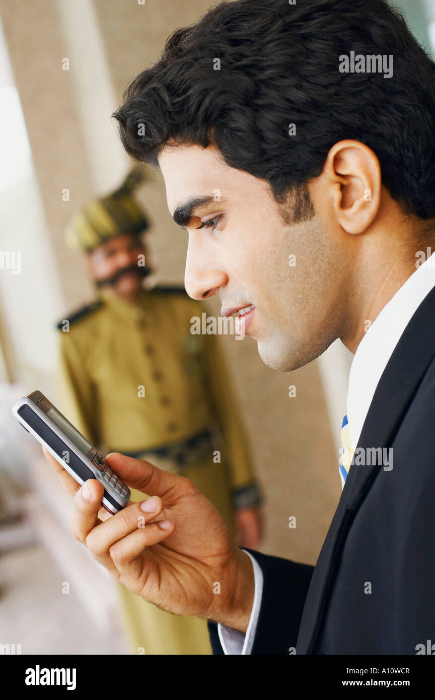 El perfil lateral de un empresario mediante un teléfono móvil Foto de stock