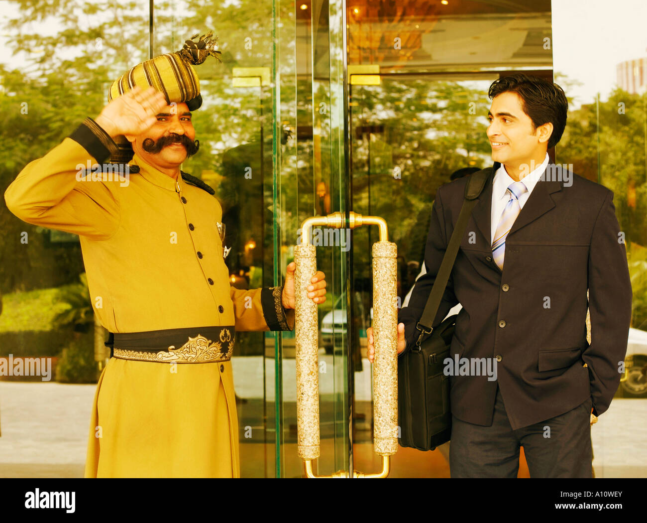 Retrato de un guardia de seguridad saludando un empresario Foto de stock