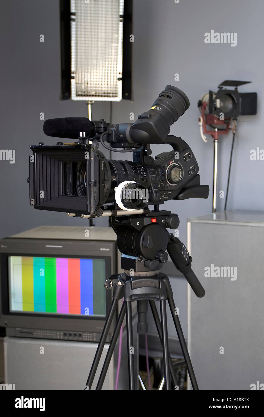 Cámara de vídeo de alta definición en un ajuste de estudio con iluminación  profesional y un monitor de televisión en el fondo Fotografía de stock -  Alamy
