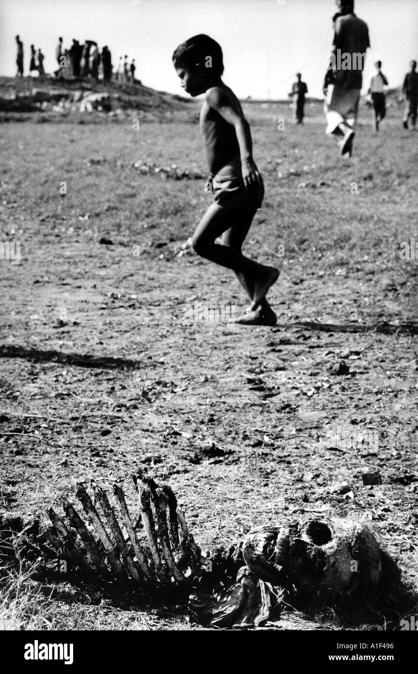 Guerra en un niño bengalí se ejecuta a través de un campo de cadáveres cerca de Dacca atrocidades pakistaníes Foto de stock