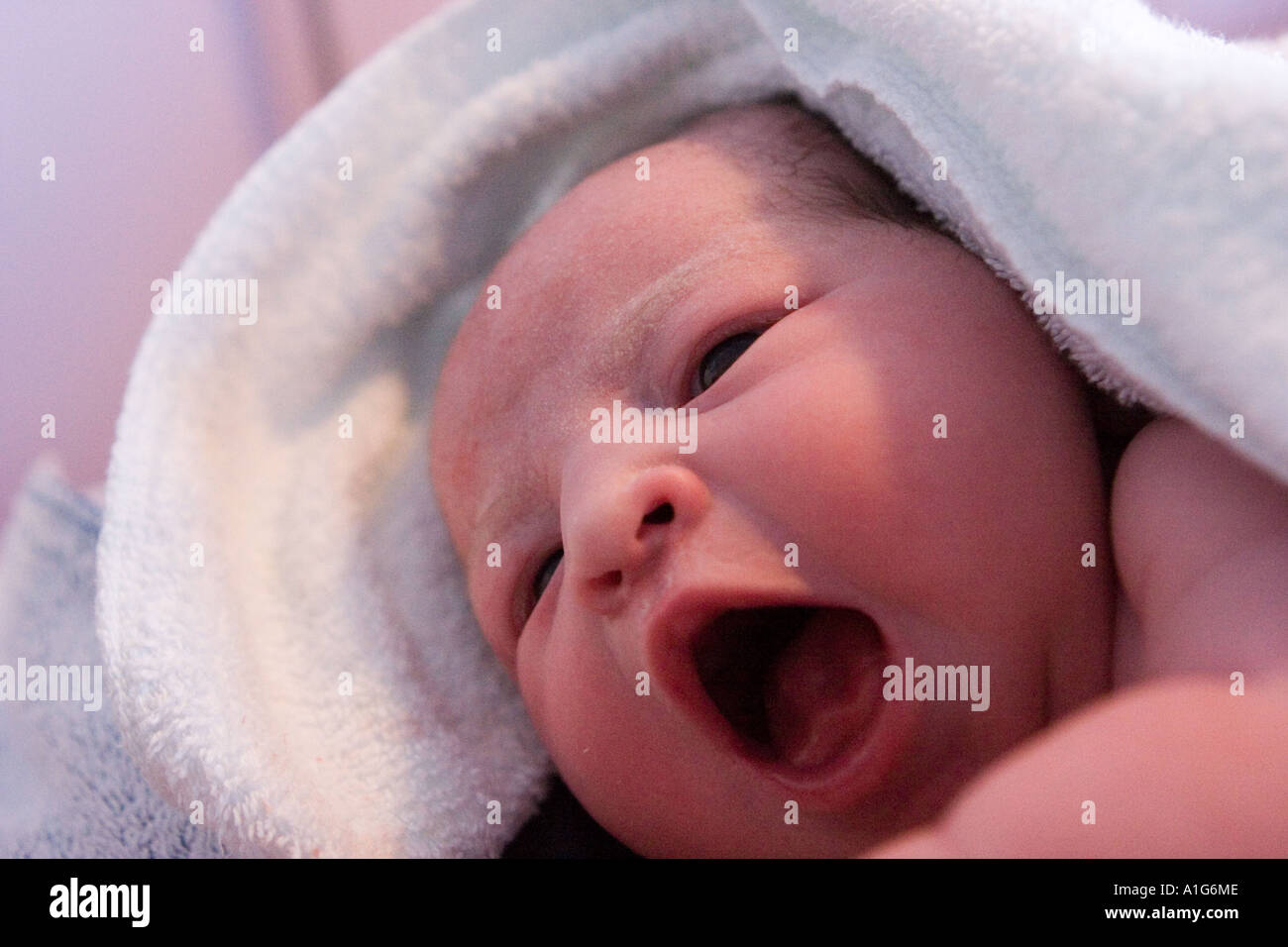 Hermoso bebé recién nacido envuelto en una toalla verde después de bañarse