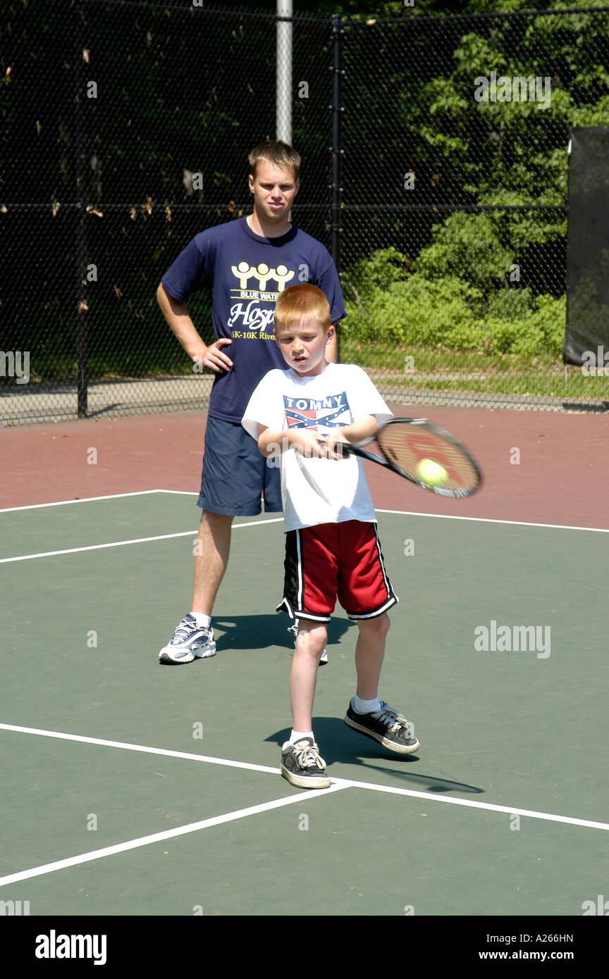 Las lecciones de tenis son proporcionados por el municipio local para ayudar a los niños a aprender el juego de tenis Foto de stock