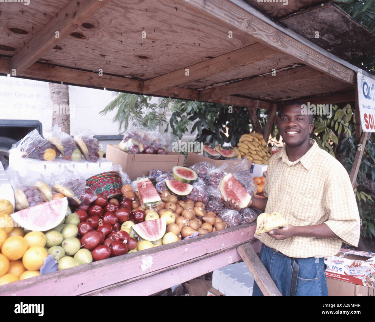 Puesto de frutas sonriente vendedor, Nassau, New Providence, Bahamas Foto de stock