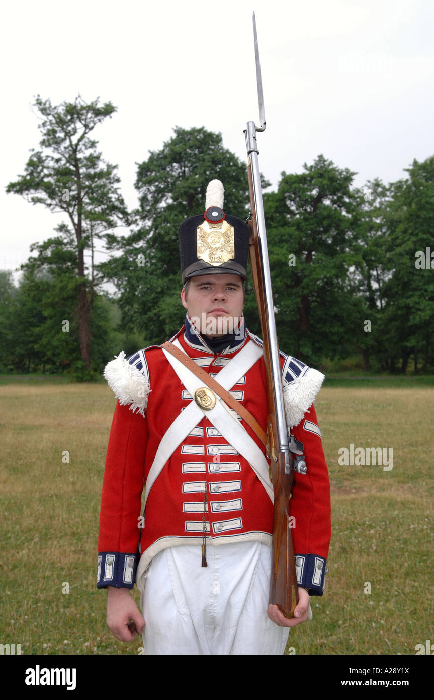Hombre en Inglés histórico uniforme de soldado con rifle y