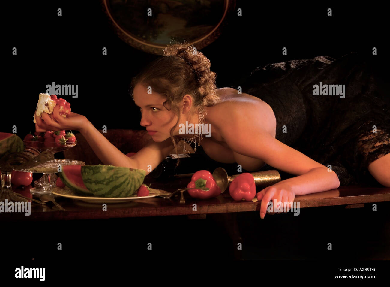 Una chica sexy sube a la mesa de la cena come torta con sus manos  Fotografía de stock - Alamy