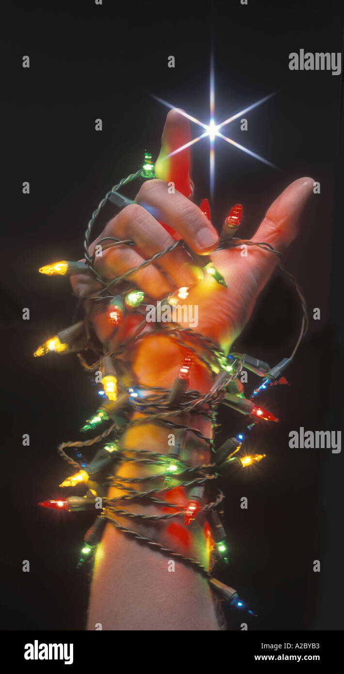 Mano envuelto en las luces de Navidad que simboliza la comercialización de  la Navidad Fotografía de stock - Alamy