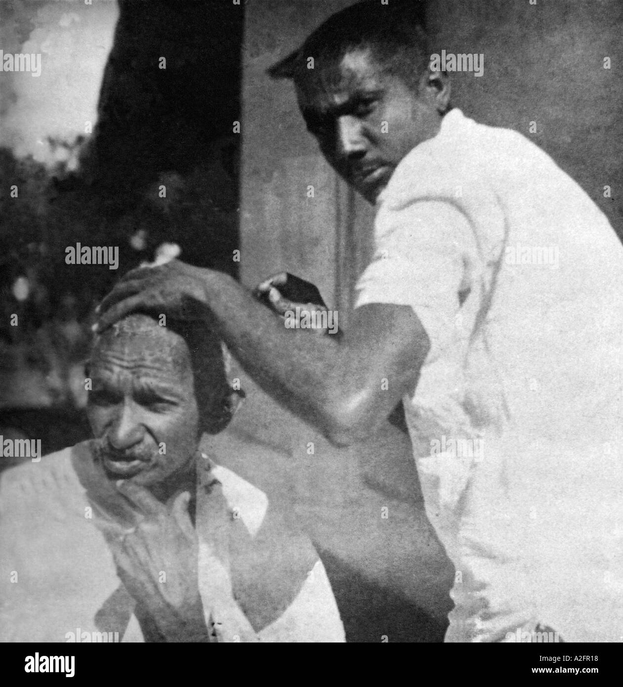 Mahatma Gandhi obtención de cabeza rapada durante la marcha de la sal India Marzo 1930 Foto de stock