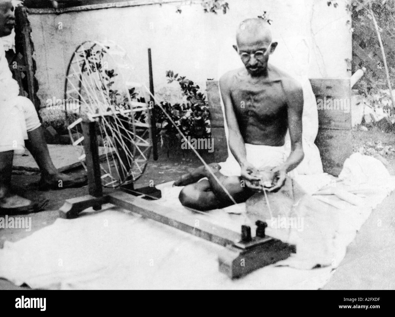 Mahatma Gandhi sentado en charkha rueda giratoria y hilo de algodón hilado en el Ashram Sabarmati en Gujarat India Asia 1925 vieja foto vintage 1900s Foto de stock