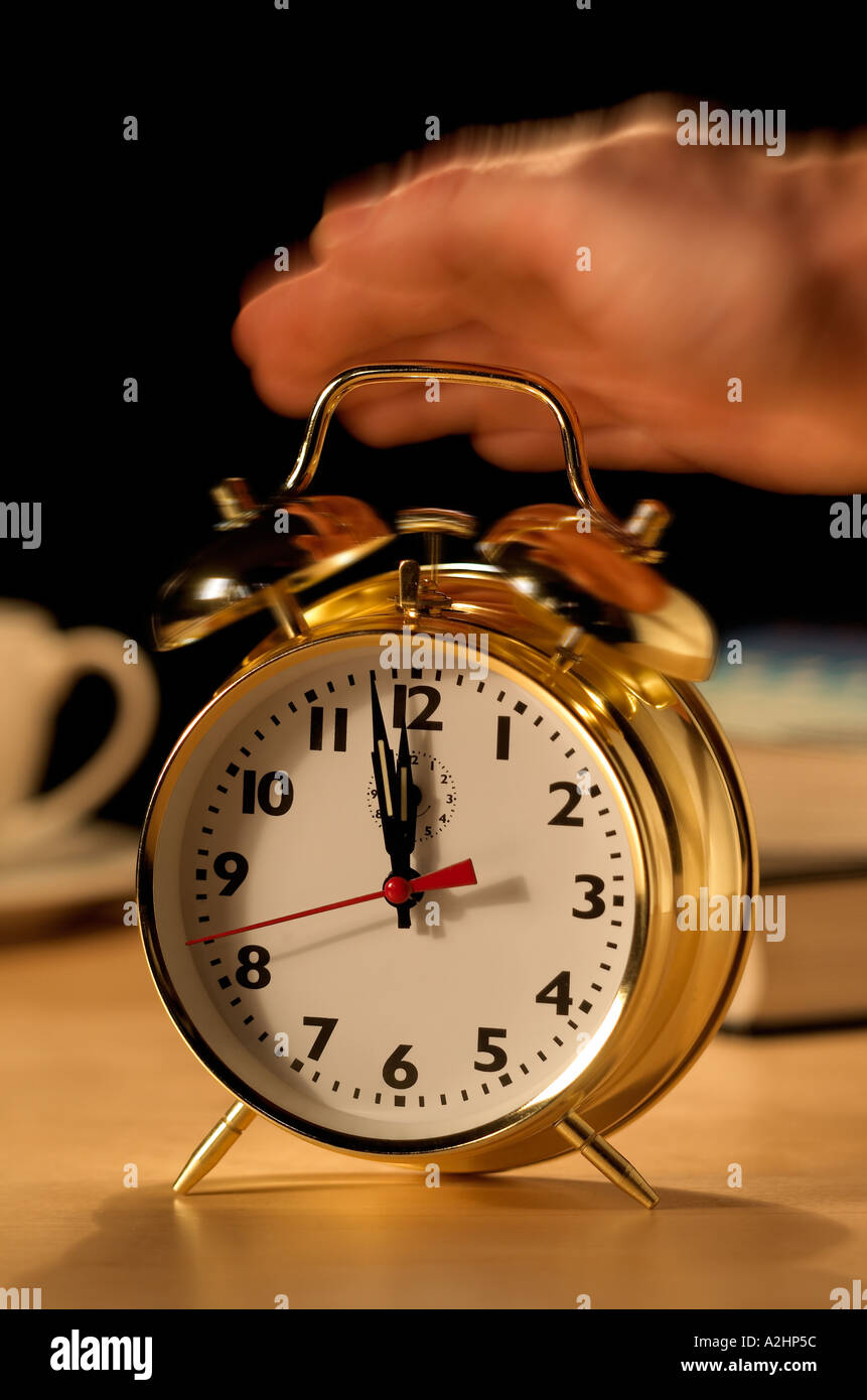 Retrato mostrando mano detener reloj alarma sonando con movimiento borrosa Foto de stock