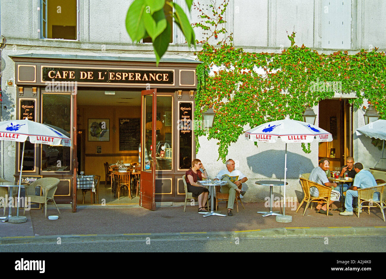 Café de l'Esperance en Bouliac en el sol de la tarde. Café tradicional  típica francesa con alguien sentado en la terraza bebiendo vino, cerveza,  café. Sol sombrillas sombrilla con texto sombreado Lillet.