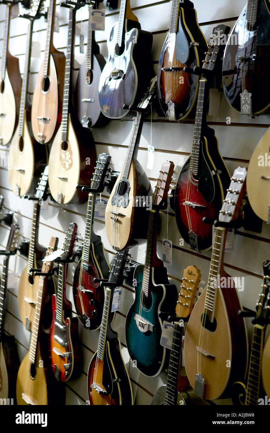 Guitarras acústicas y mandolinas en venta en una tienda de instrumentos musicales Foto de stock