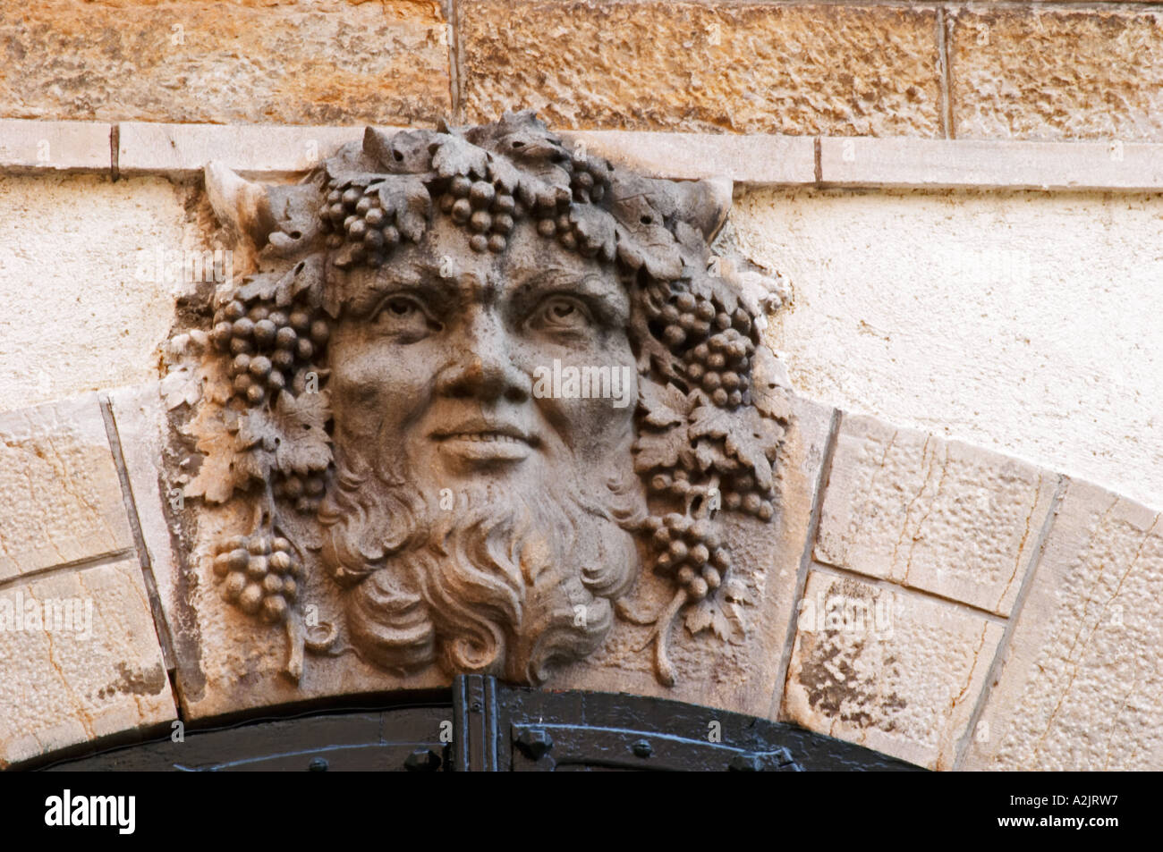 Una escultura de baccus bacchus baccus con barba y racimos de uvas y hojas de vid en el cabello como la lápida clave keystone Foto de stock