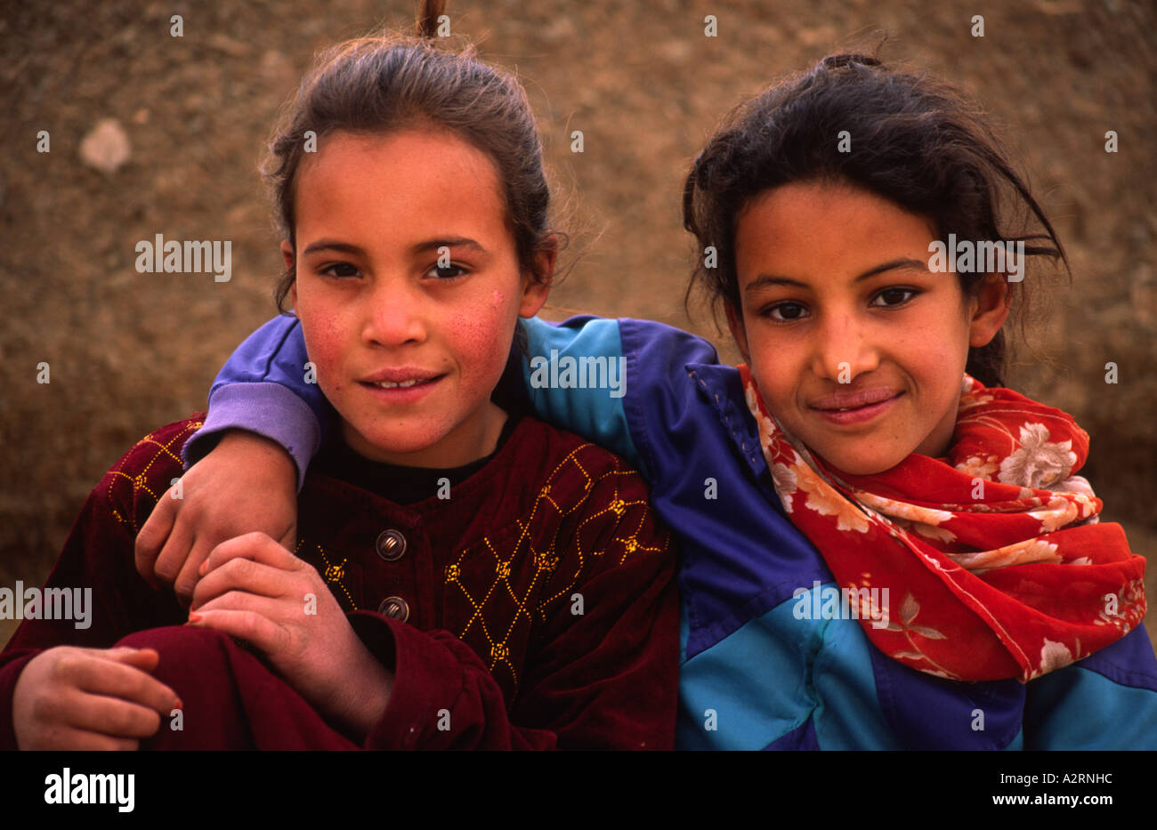 Dos niñas marroquíes agradable sentarse juntos sonriendo ante la cámara, en  los campos al borde del Sáhara, Marruecos, Norte de África Fotografía de  stock - Alamy