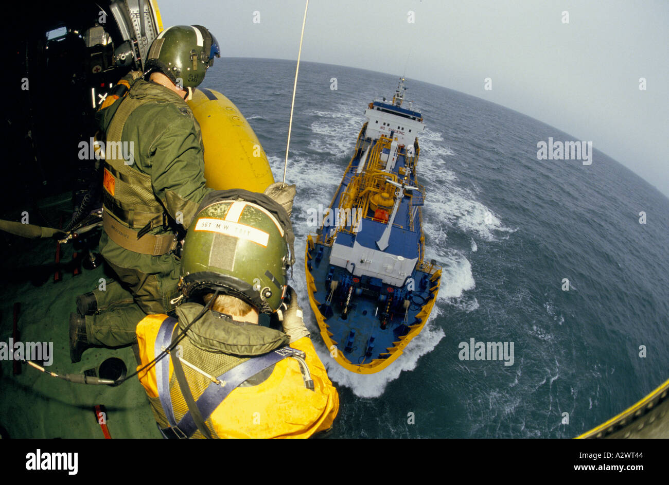 Raf aire tripulación aérea de salvamento marítimo con cascos en aeronaves de rodillas por cabina abierta salir gran barco en el mar Foto de stock