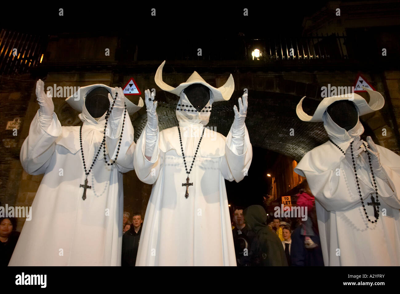 Tres hombres vestidos como monjas fantasmales con rostros negros y rosarios  y cruces orando Halloween Derry Irlanda Fotografía de stock - Alamy