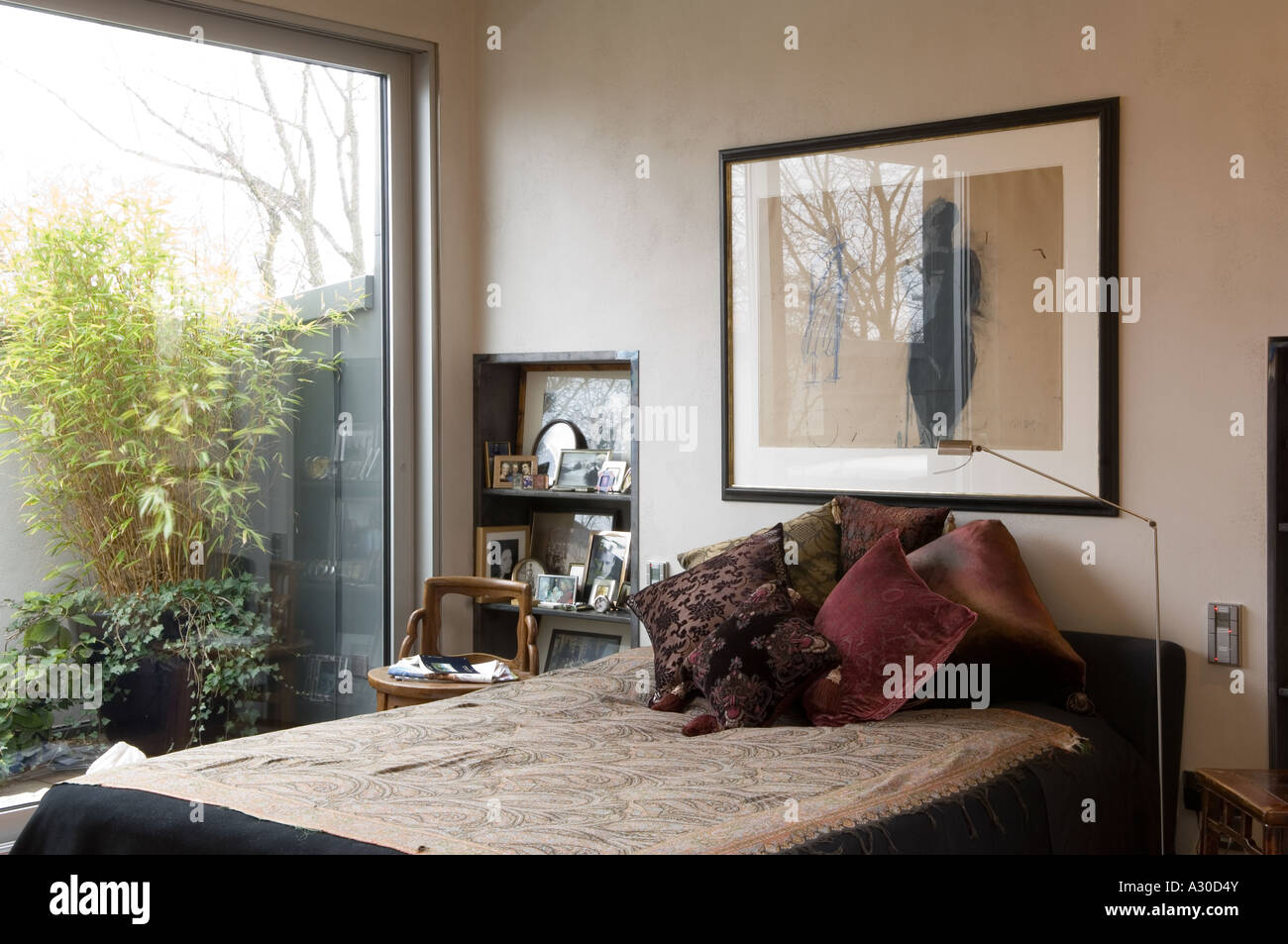 Habitación con un gran ventanal que da al jardín de la azotea en moderno apartamento atico Foto de stock