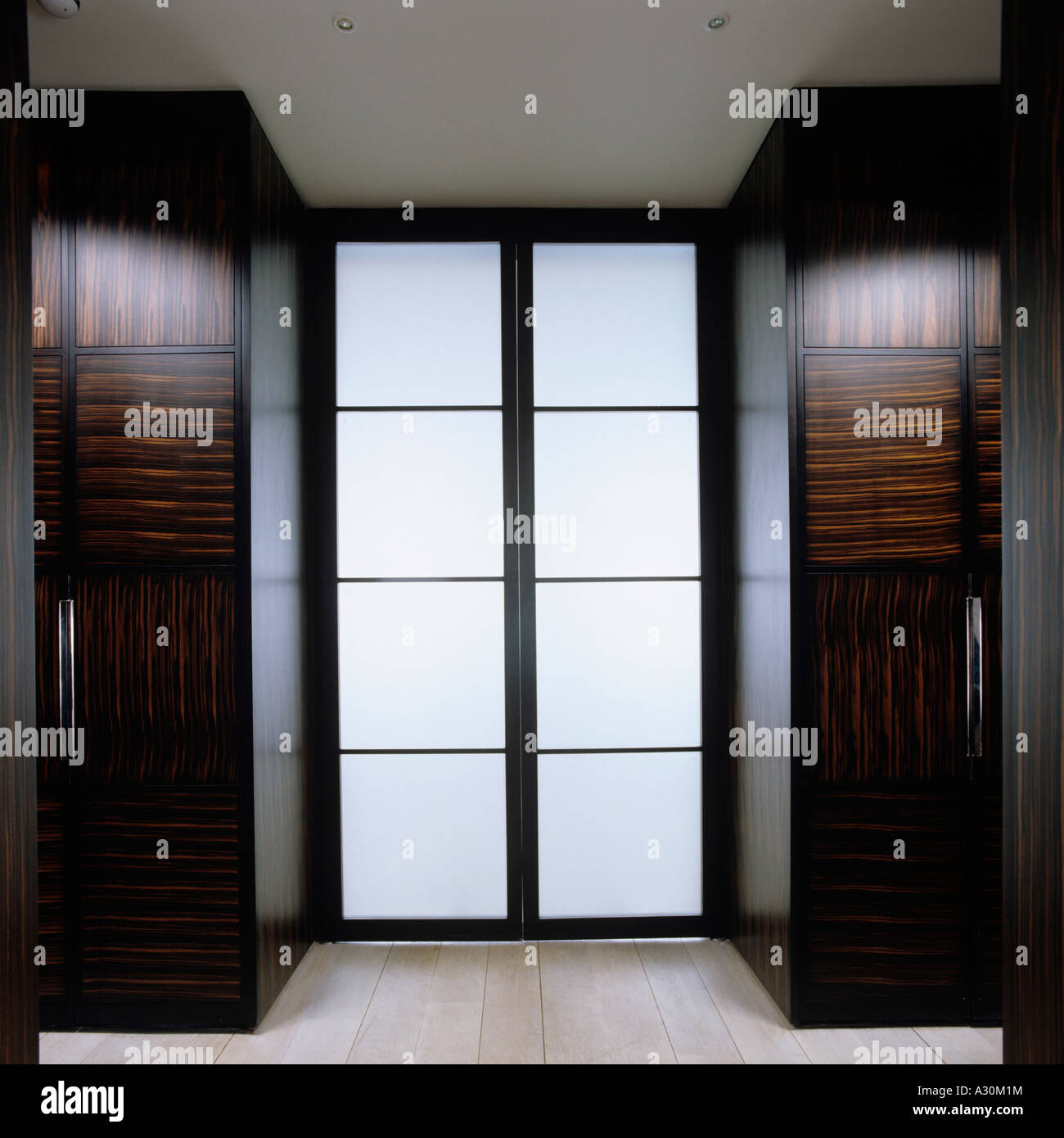 Puerta de vidrio doble con dos armarios de nogal pulido Foto de stock