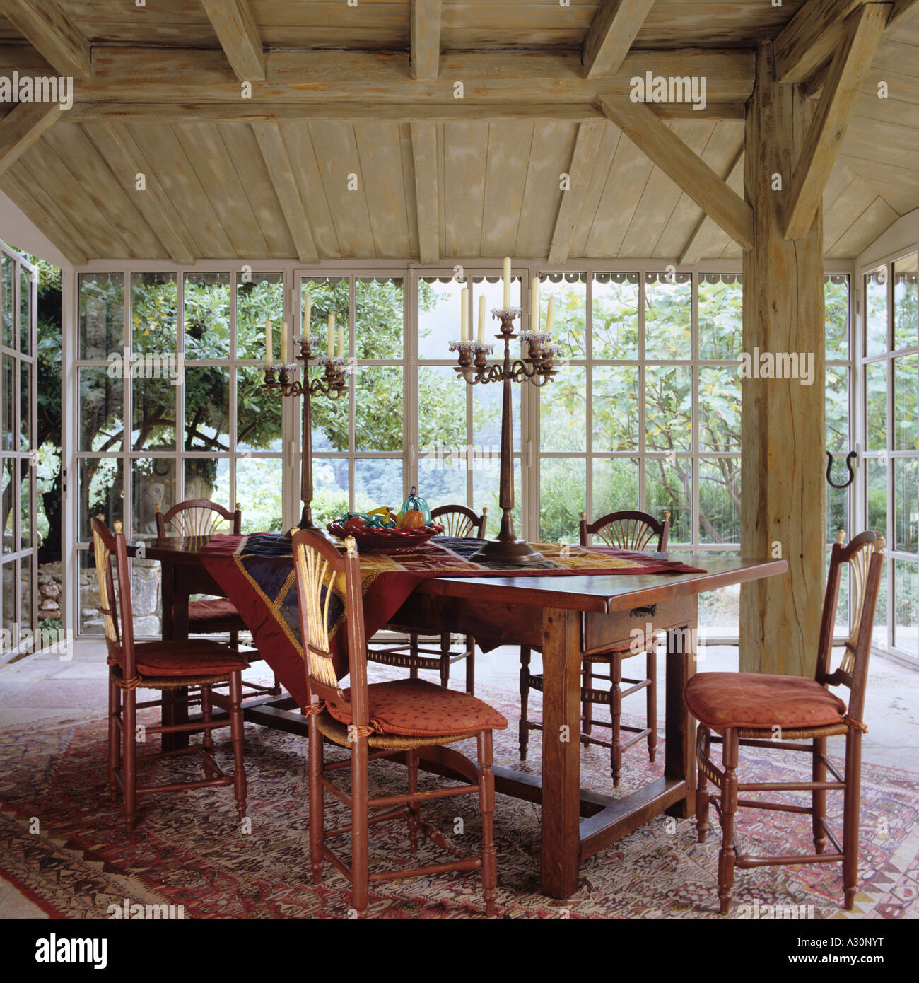 Mesa y sillas en la alfombra en el granero de madera-como el conservatorio Foto de stock
