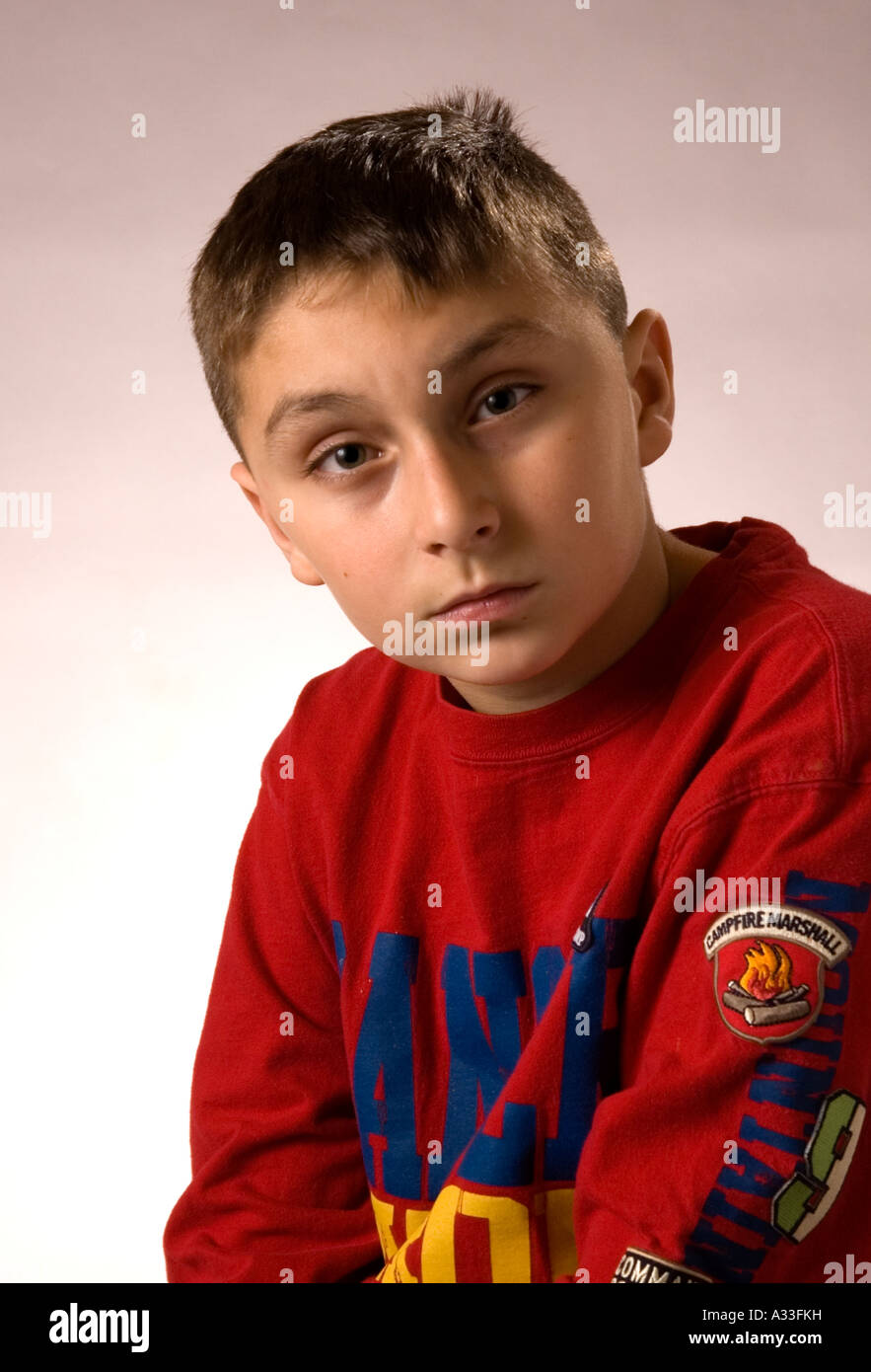 Niño de 10 años, posa para la cámara en una configuración vertical ...