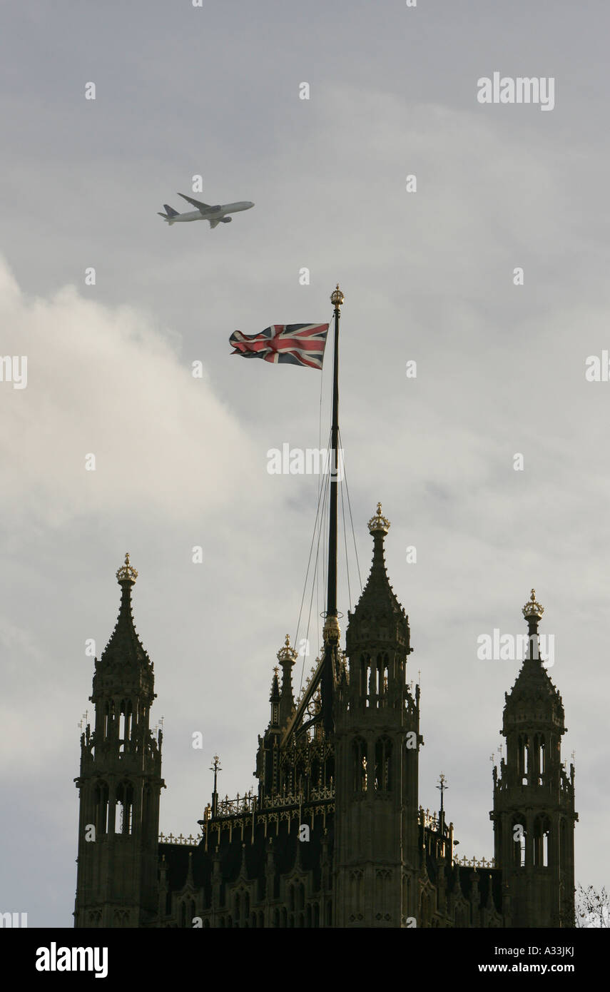Un avión vuela por encima de las casas del parlamento de victoria edificios torre en Londres Inglaterra Foto de stock