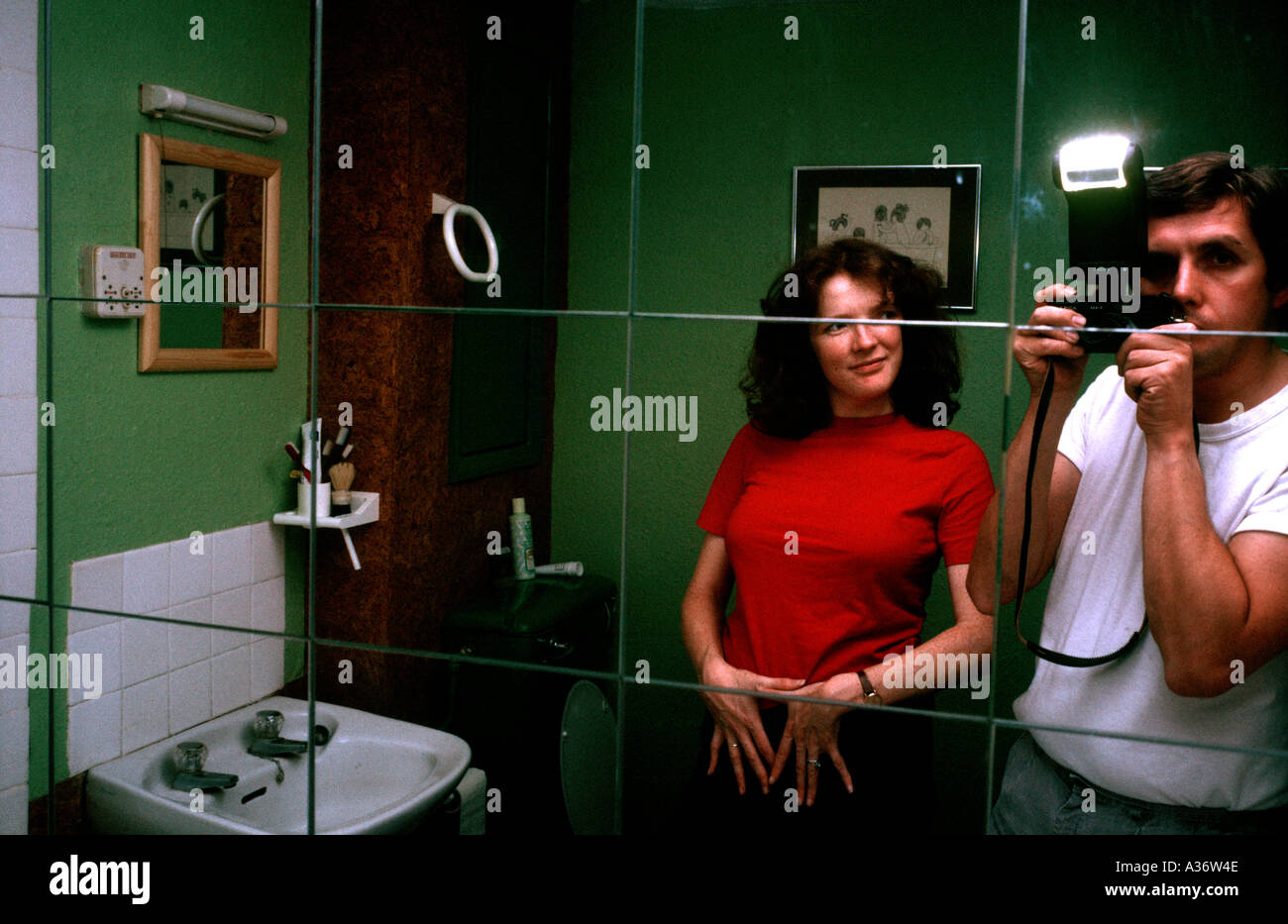 Pareja en un espejo del baño autorretrato con cámara y flashgun Foto de stock