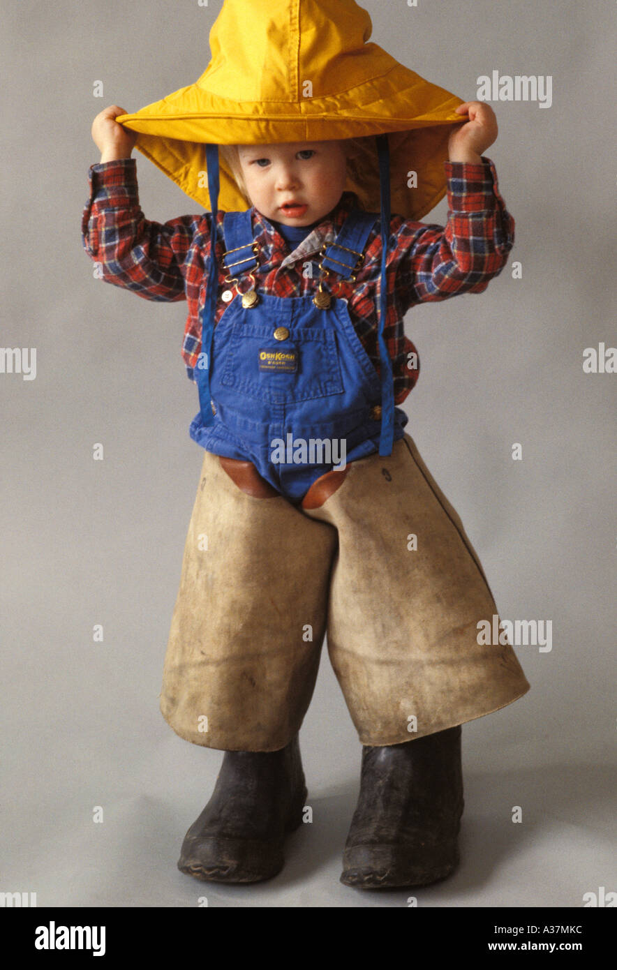 Un niño de 2 años, trata de ropa impermeable Foto de stock