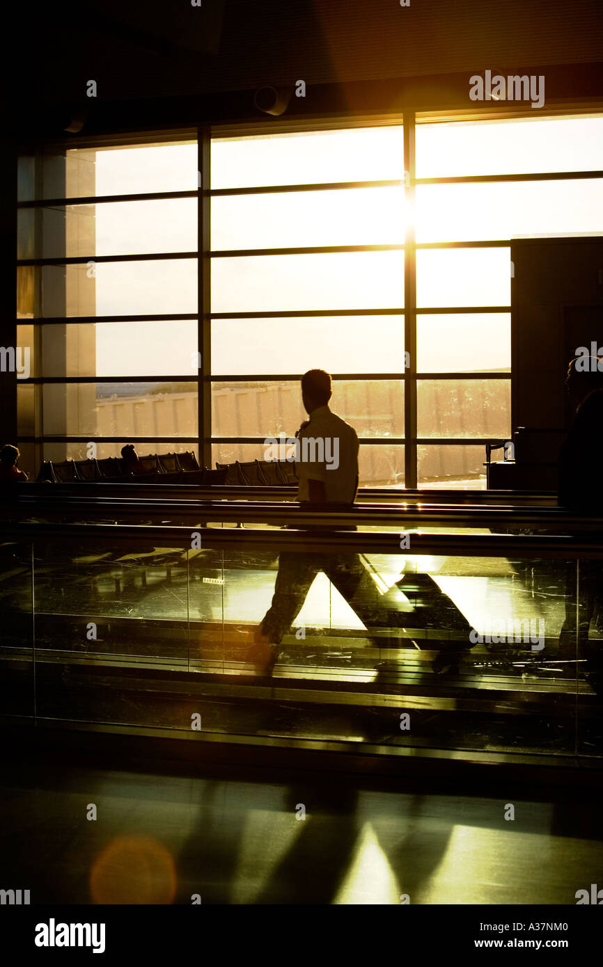 El hombre en el andén móvil en silueta en el aeropuerto de Detroit, MI Michigan Foto de stock