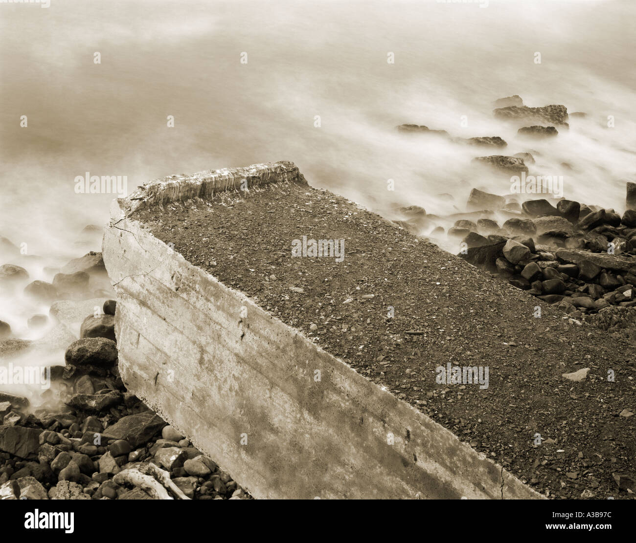 Una feroz tormenta costal y degradados desmoronándose bridge sobresaliendo por el mar Foto de stock