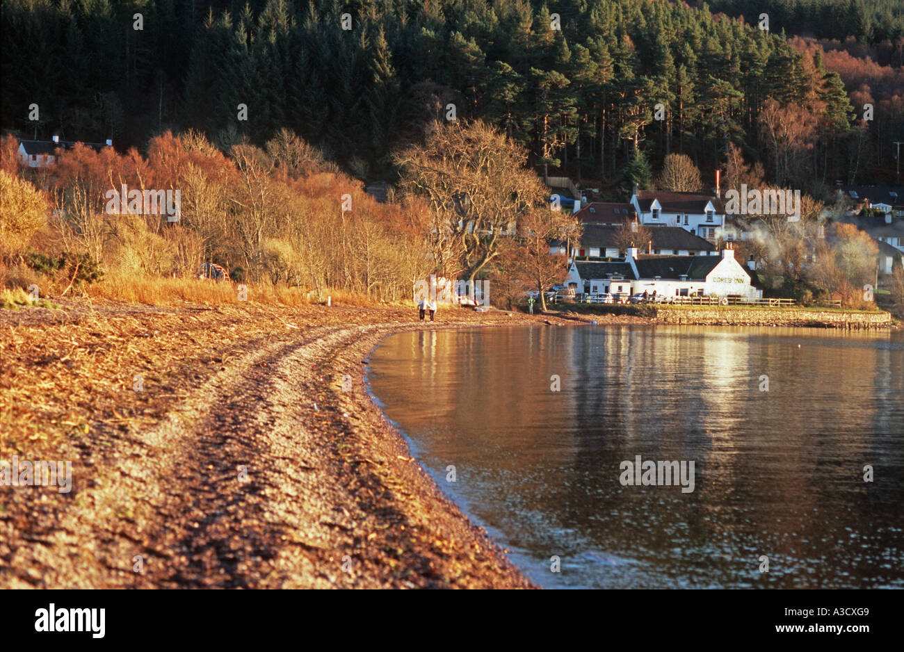Una playa en el Lago Ness dores con la Dores Inn en el fondo Foto de stock