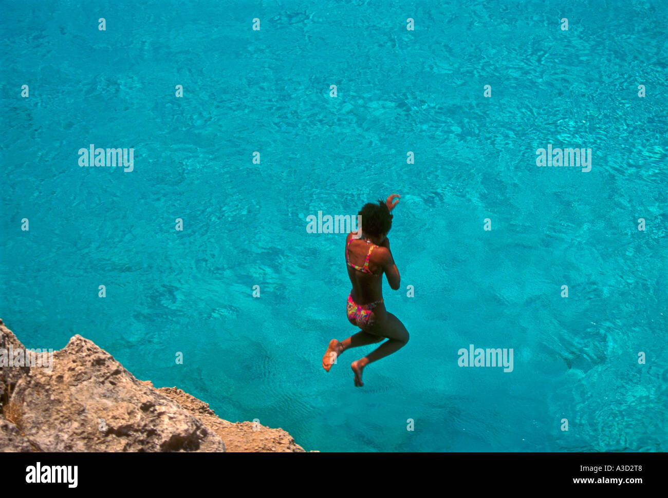 Curacaon mujer, joven mujer adulta, joven, saltar al agua, big knip beach, bahía knip, Curacao, Caribe Foto de stock