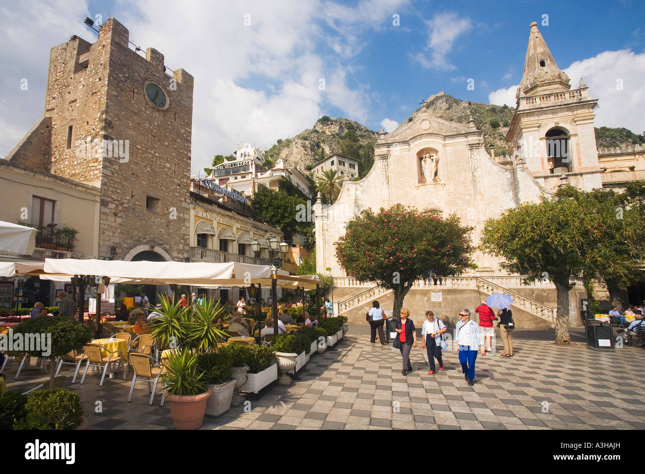 El 9 de abril de Piazza cuadrado y la iglesia de San Agustín con turistas en Sol sol y cafés Taormina Sicilia Italia Foto de stock