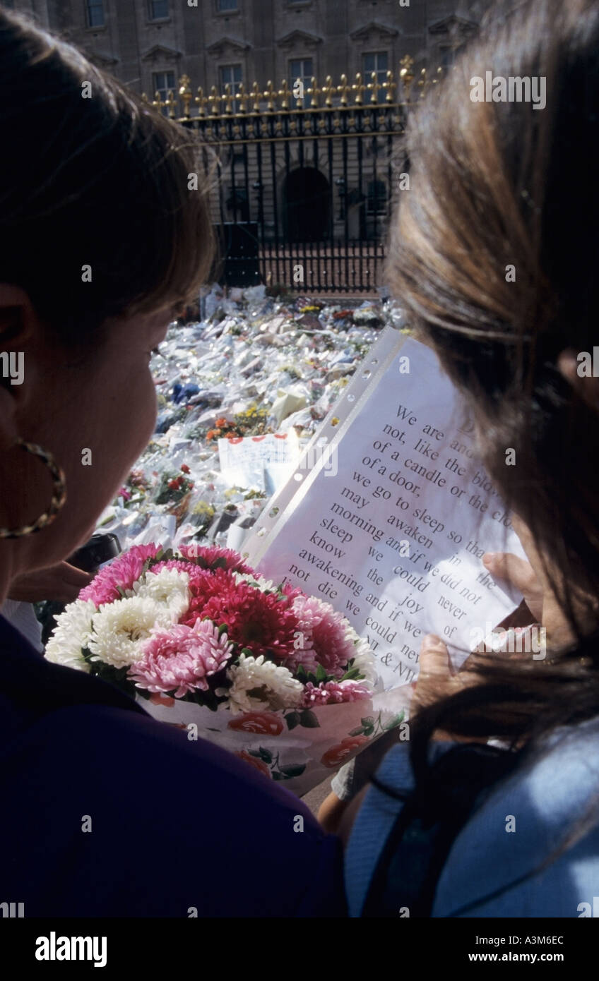 Palacio de Buckingham Londres 2 muchachas con flores mostrar mensaje de homenajes florales tras la muerte de la Princesa Diana Foto de stock